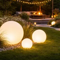 Ogród nocą rozświetlony kulistymi lampami solarnymi, tworzącymi magiczną atmosferę.