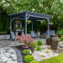 Idealny pomysł na kącik wypoczynkowy w ogrodzie: pergola, kamienny kominek, wygodne fotele i fontanny.