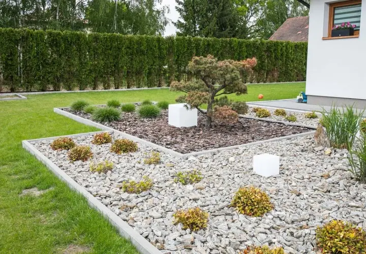 Nowoczesne klomby ogrodowe wzory z kamienia i kory, z bonsai i białymi sześcianami.