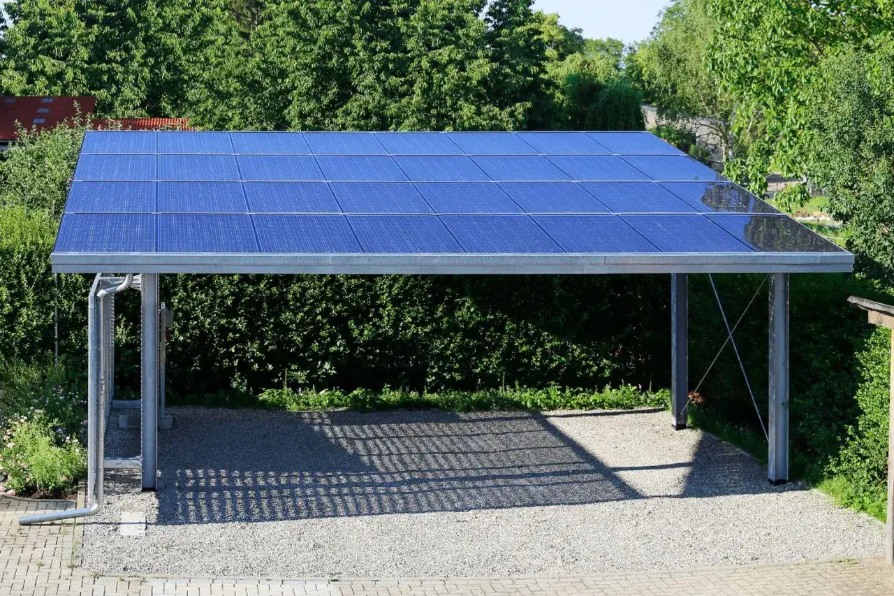 Nowoczesna wiata z panelami fotowoltaicznymi w ogrodzie. Czysta energia słoneczna zasila dom.
